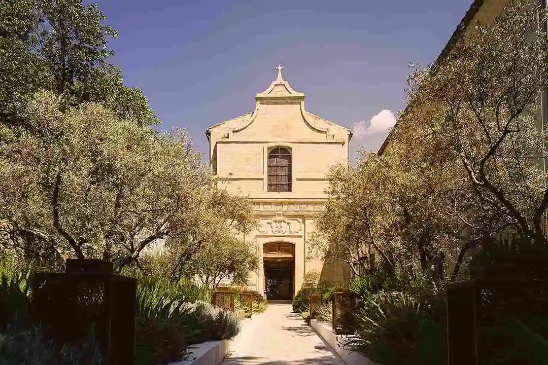 A Provençal bell tower with a lavender-lined pathway, reflecting the land from which L'Occitane en Provence has drawn its iconic ingredients