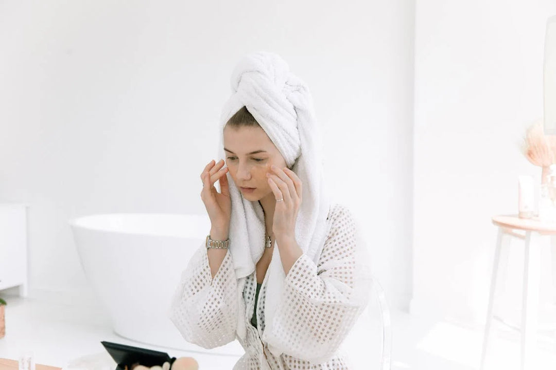 women in white towel doing skincare routine